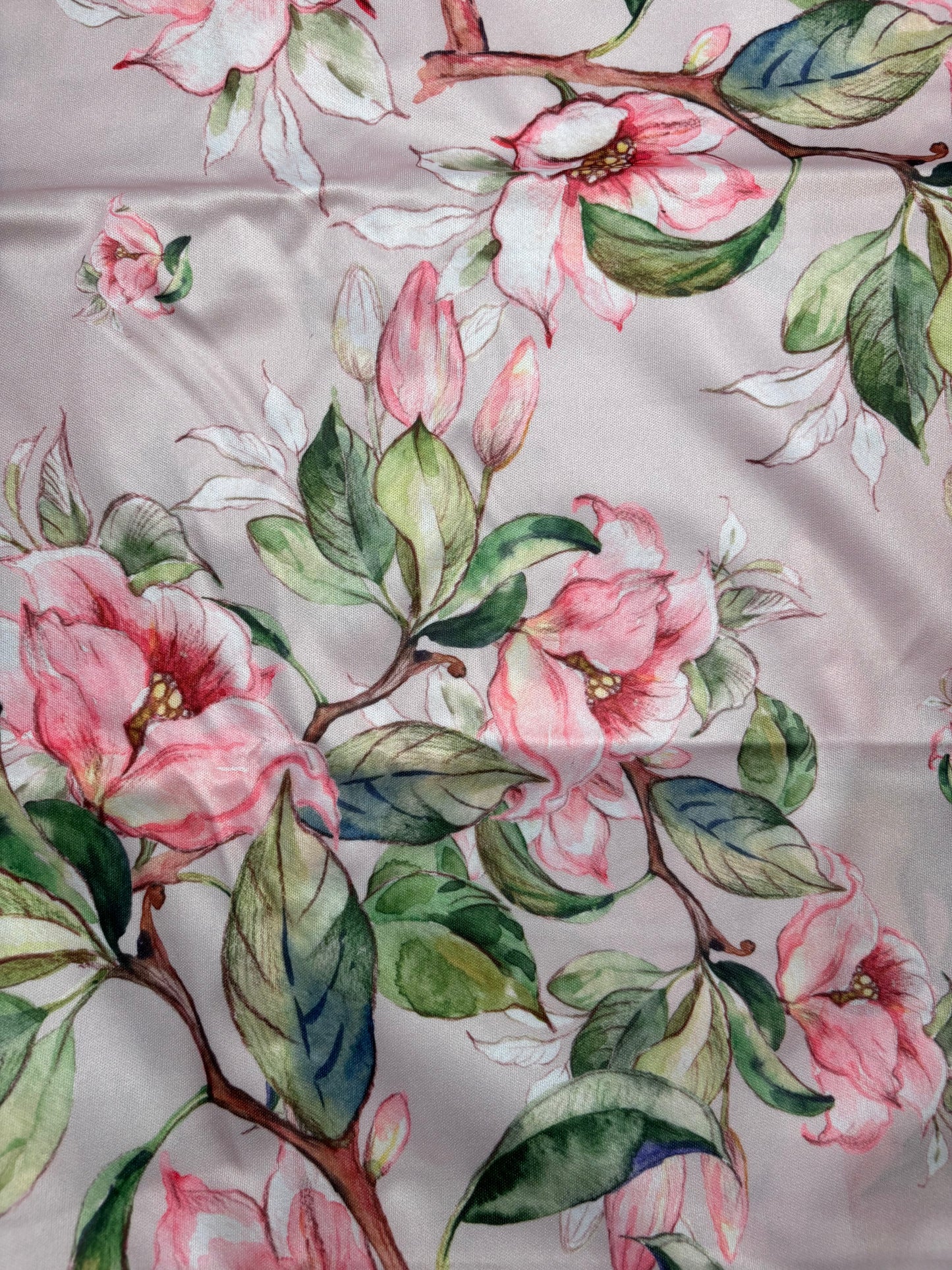 Floral pattern with pink flowers and green leaves on a fabric background