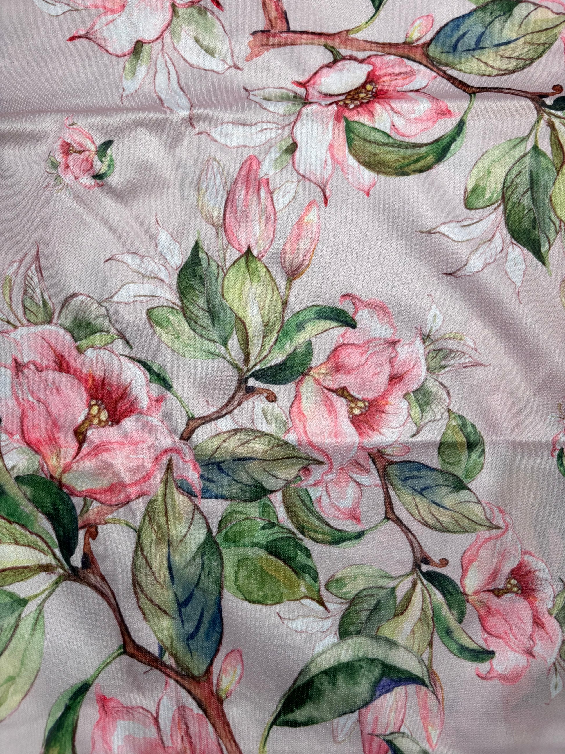 Floral pattern with pink flowers and green leaves on a fabric background